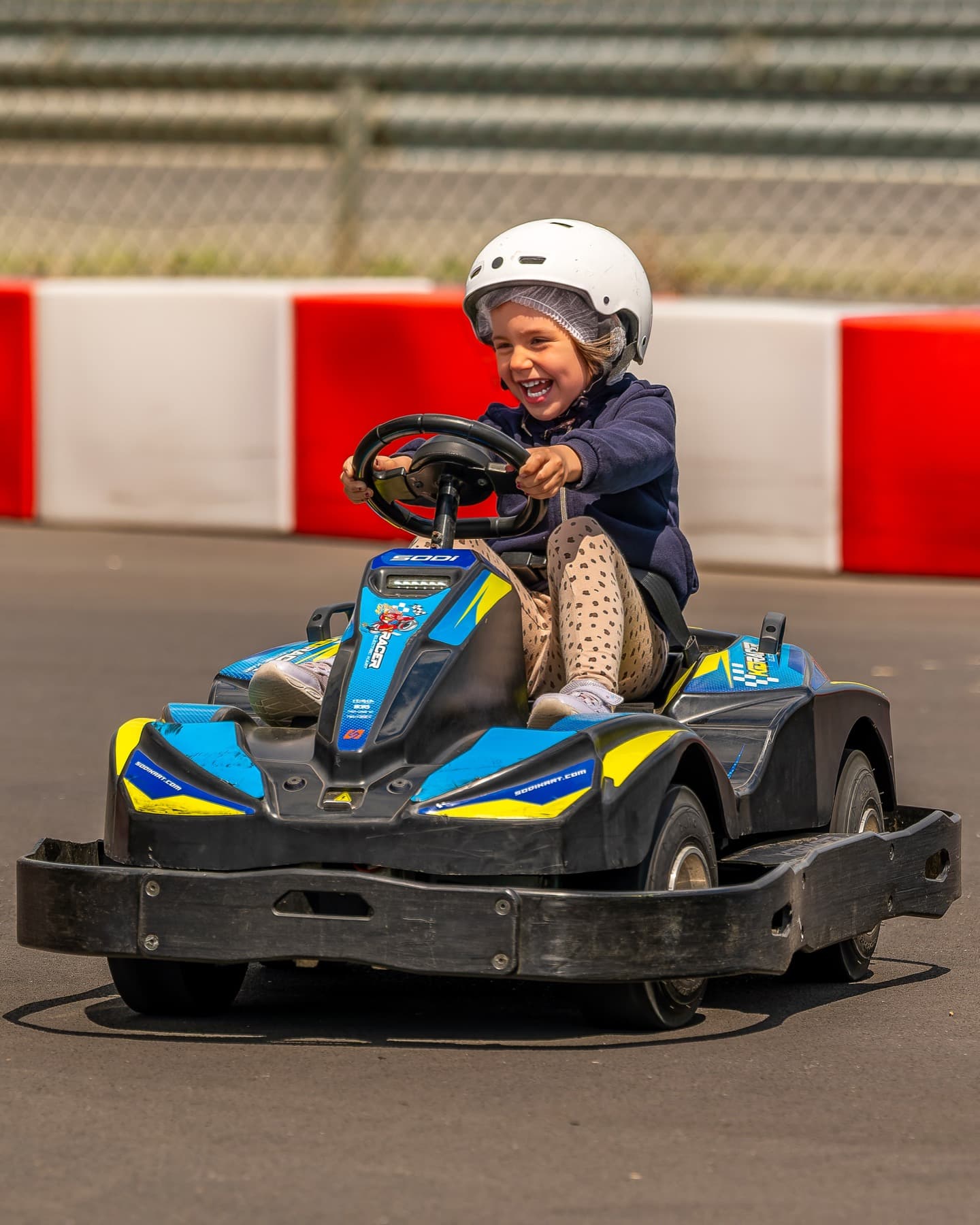 Enfant hilare au volant d'un kart lors d'un anniversaire chez MegaKart